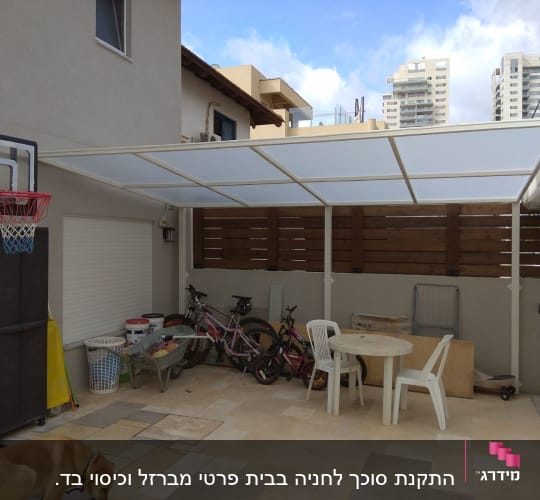 סוכך לבן מתכת עם לוחות שקופים בחצר